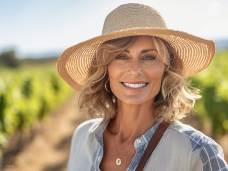 Sun protection essentials, including a wide-brimmed hat and sunscreen, to safeguard post-facelift results
