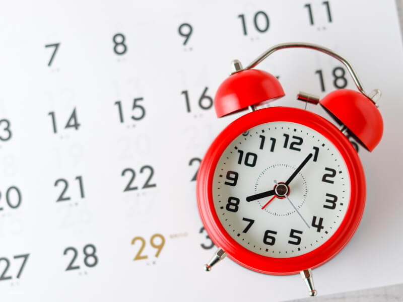 an image of a clock and calendar indicating that timing is important when deciding on tummy tuck surgery