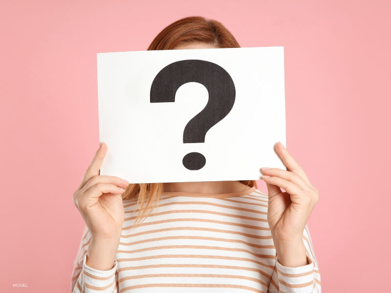 visual of a woman with a question mark indicating the need to start preparing for breast augmentation by asking questions