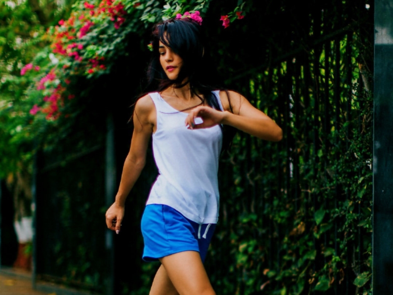 A happy confident woman out and about in active wear, symbolizing self-assurance and body confidence after a procedure like liposuction.